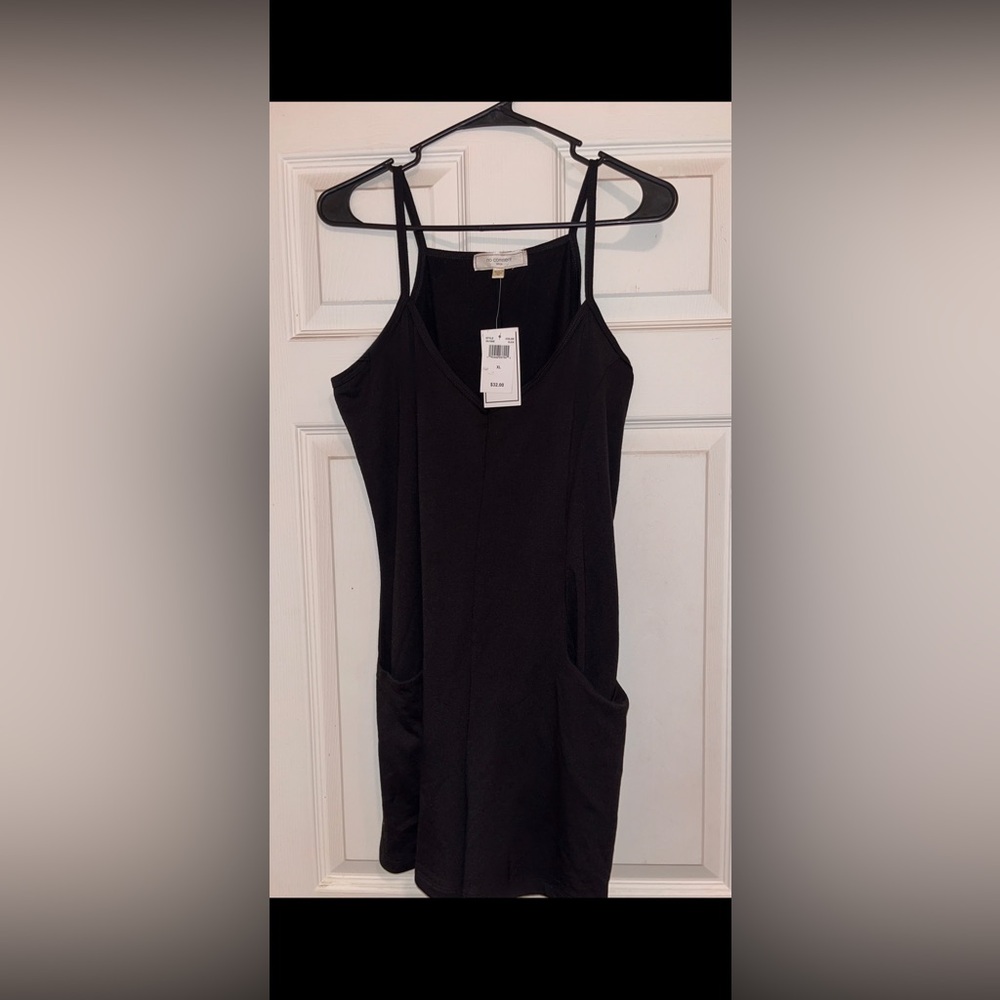 new black spaghetti strap romper w/ front pockets and tags.